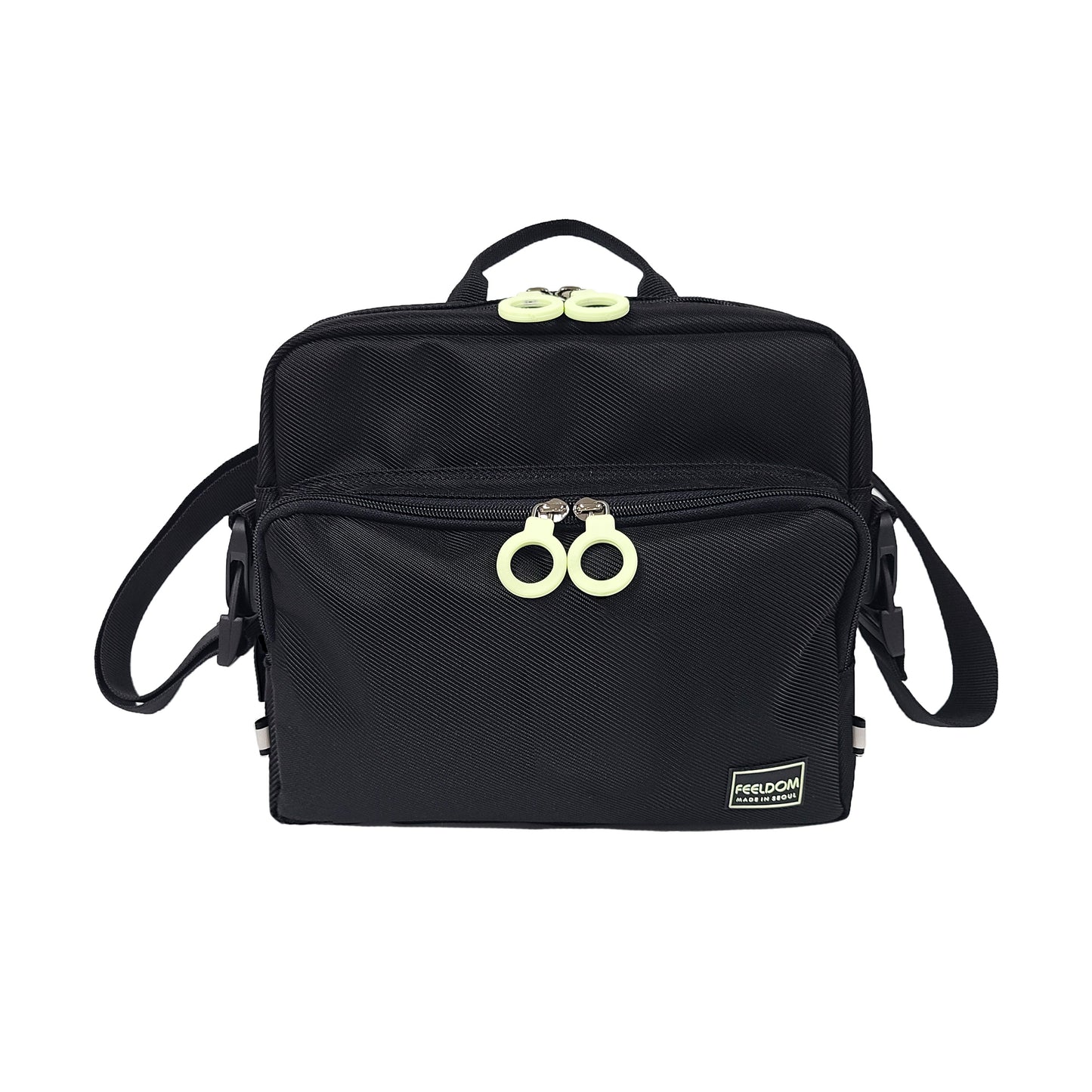 Front view of a black satchel with a zipper pouch on the front and a handle on top. Double zipper rings on the top and front pouch are white rings.
