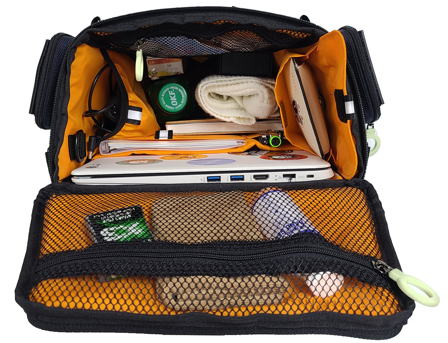 Inside view of the open CITY BLOCK backpack, completely stuffed with items in the top, sides, front and back of the bag, looking down into the bag. The lid pouch has personal hygiene items, the side pouch has cords and cables. the right side has sunglasses in one pouch and a wallet . There are laptop , diary, pens, bottle, snacks, etc.