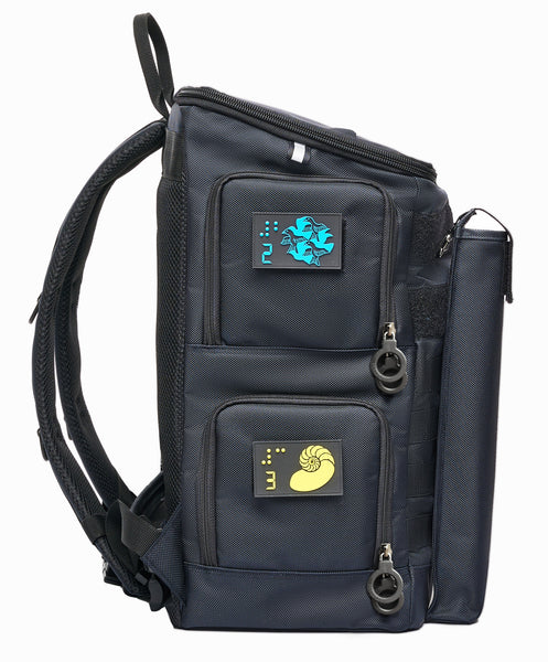 Side view of navy blue Large. Side access points on upper and lower levels have double ring zippers and colored braille patches for identification, Yellow and Blue. Cane pouch is attached vertically to the front by velcro