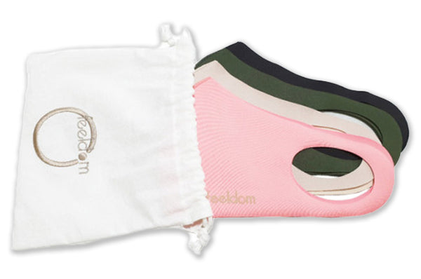 Four colored masks are halfway inserted into the white cotton pouch