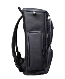 Side view of a large navy blue backpack with a tall box shape and side pockets.
