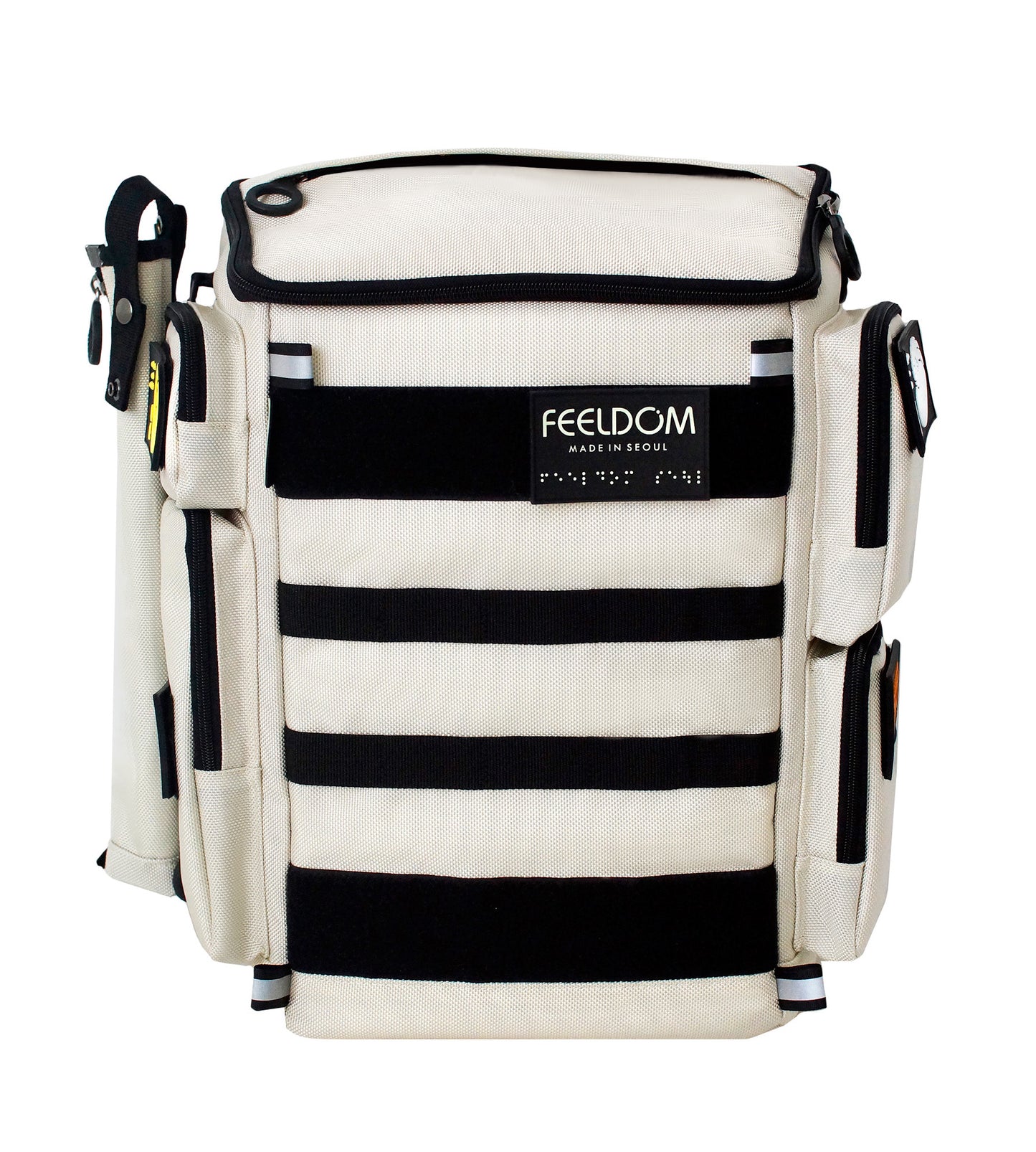 An Ivory white backpack with black trim and cane pouch attached to the side. Backpack has black MOLLE webbing on the front and Braille design patches and FEELDOM Branding.