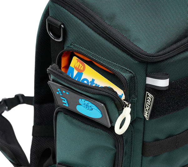 Close up view of the City Block Top right pocket, which is big enough to hold a small wallet or some cards and medications. There is a Yellow NY Metro card inside the pocket, which has a white zipper ring and a blue design patch of a Nautulus Shell and number 3 in braille.