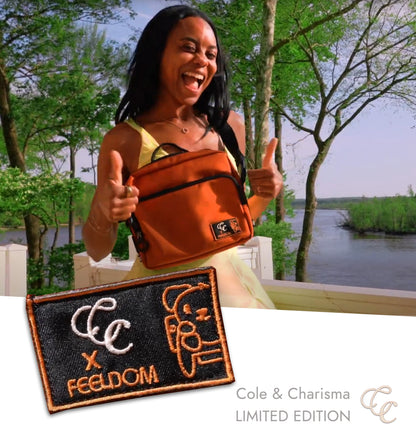 Woman holding an orange bag with a scenic background, featuring a limited edition patch from Cole & Charisma, LIMITED EDITION