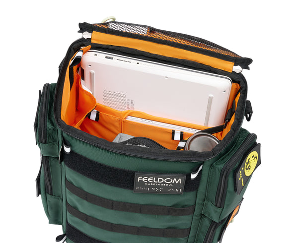 An open view of the City Block backpack in Forest Green with a bright orange lining. The lid is flipped open to show a 17-inch laptop stored in the widest pouch, a large thermos in the inner side pouch, and a small i pad in the slimmer pouch. There are several more pockets on the lid and sides of the bag, which have a reflective tab for visibility.