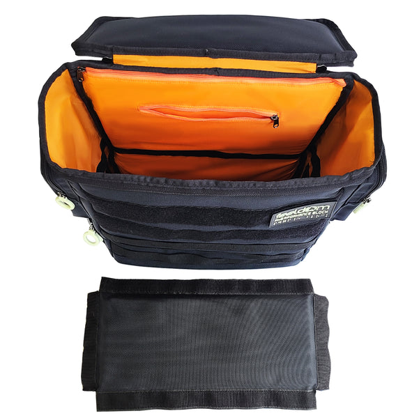 Front view of open top, looking into the Performance Block medium backpack. It is dark navy with a bright orange lining.  The horizontal divider is removed and set in front of the backpack.  It is a rectangle with velcro along all four edges.  Inside the bag there is a velcro strip that goes all the way around the center of the bag.  There is a small zip pocket on the upper inside back wall.