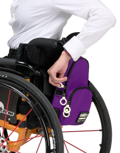 A small purple bag attached to the back of a manual wheelchair. It has white zipper rings for easy access.