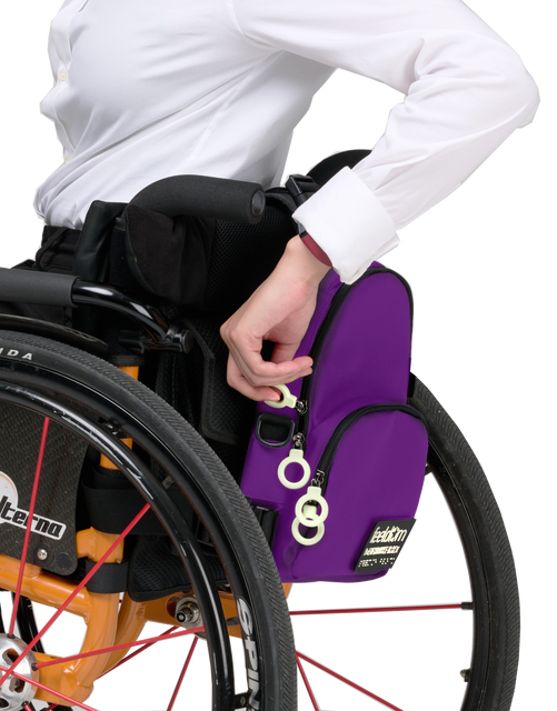 A small purple bag attached to the back of a manual wheelchair. It has white zipper rings for easy access.