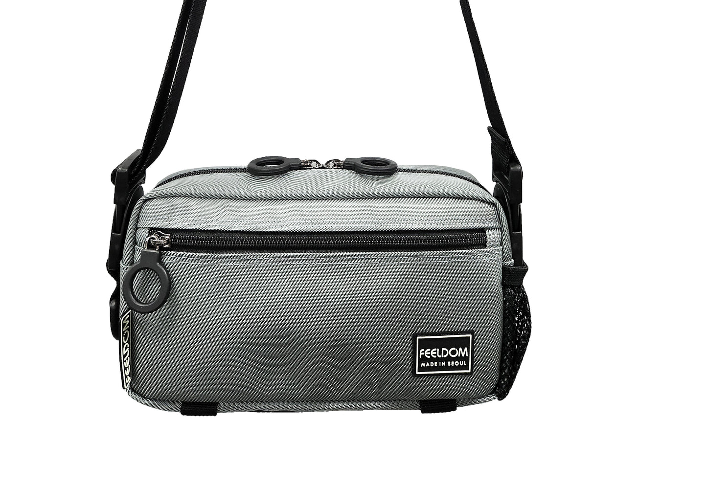 A silver colored adaptable  crossbody bag with black trim and black zipper. The strap is in crossbody / shoulderbag mode.