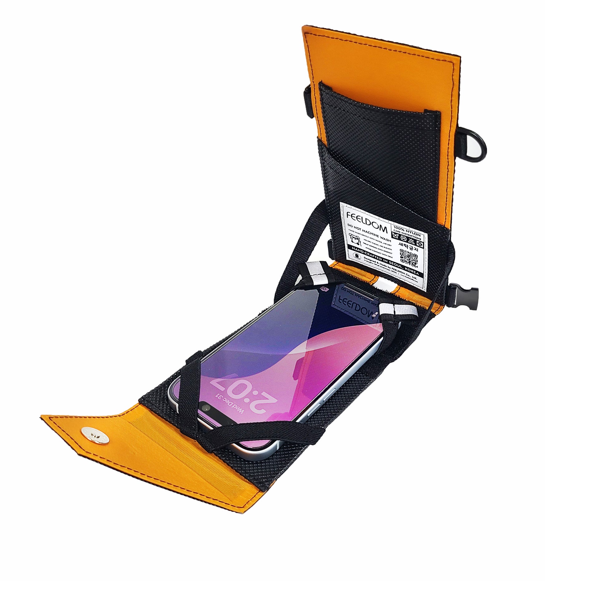An open flip case with a smartphone in portrait mode attached to the inside front and card slots along the back of the case.  It's black with an orange lining.
