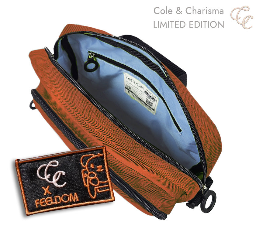 Brownish-orange bag with open zipper, showing sky blue interior and 'CC x FEELDOM' embroidered patch