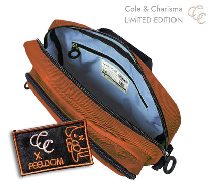 Brownish-orange bag with open zipper, showing sky blue interior and 'CC x FEELDOM' embroidered patch