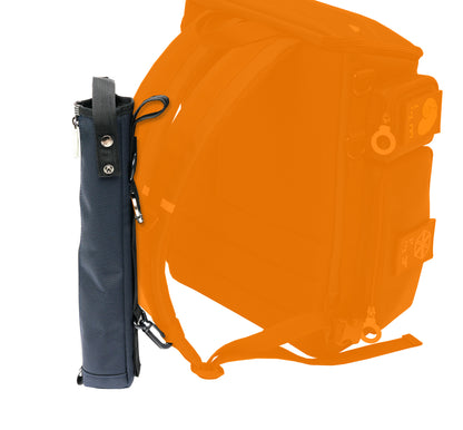 Detail of a navy blue cane pouch attached to the straps of the City block backpack. The carabiner attaches to the D-ring of the strap, while the smaller clip at the bottom of the pouch attaches to the lower part of the strap to help it be stabilized.