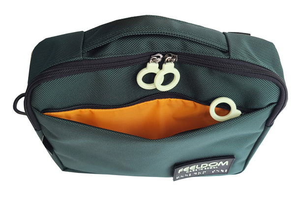 Top view of a forest green TEKNO Pouch with the front pocket open to show an orange lining inside. The ring zippers are white. There is a handle on the top of the bag