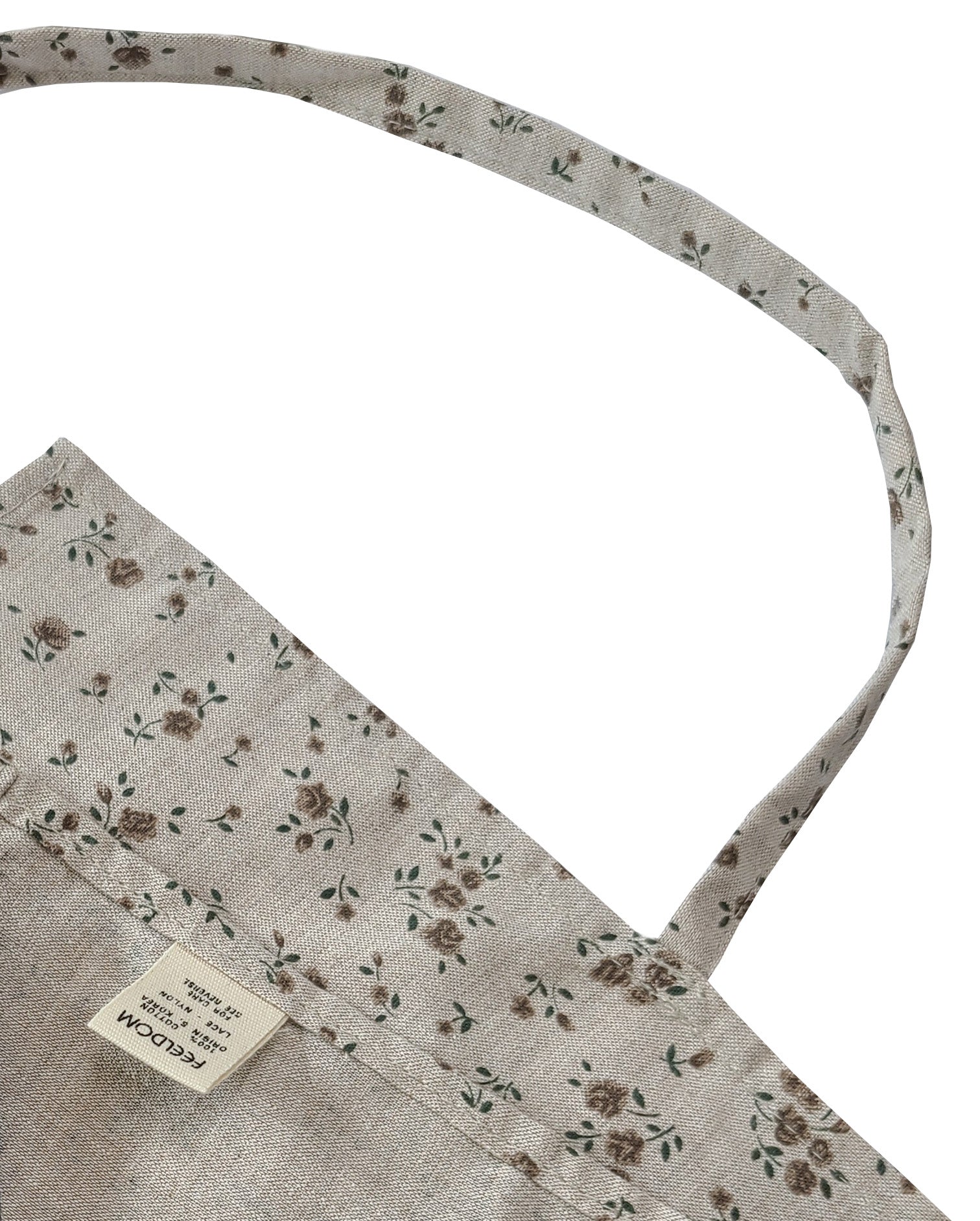 Close up of Feeldom Country Flower apron scarf showing the craftsmanship and quality of the neck strap and seams, including the reverse corner with a feeldom tag.