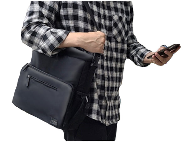 A guy in a plaid shirt is carrying the Feeldom Chic Medium Adaptable tote on his shoulder. Modern and unisex design fits any person and situation with class, functionality and style.
