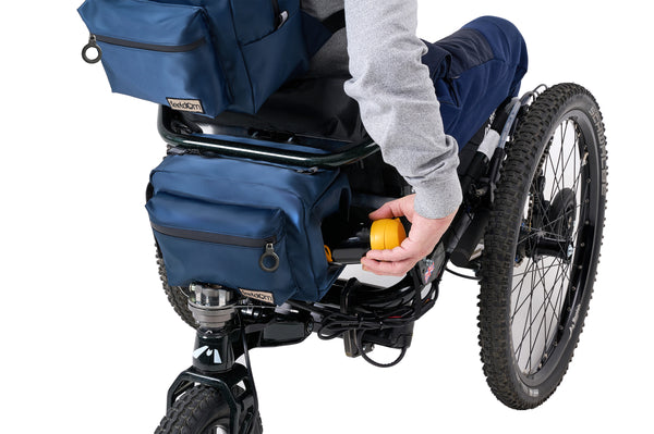 Person reaching back into the Buddy Sport cooler to take out a thermos. Side access panel zips open. Front pocket has a black zipper and ring pull. Buddy sport fits great on outdoor Mountain Wheelchairs.