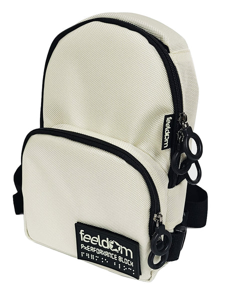 Front angle view of an ivory white crossbody bag that has an arched top and a smaller zipper pouch on the front which covers the bottom half. It has double black zipper rings each pocket, and a glow-in-the-dark Feeldom Logo patch on the front which is removable by velcro.