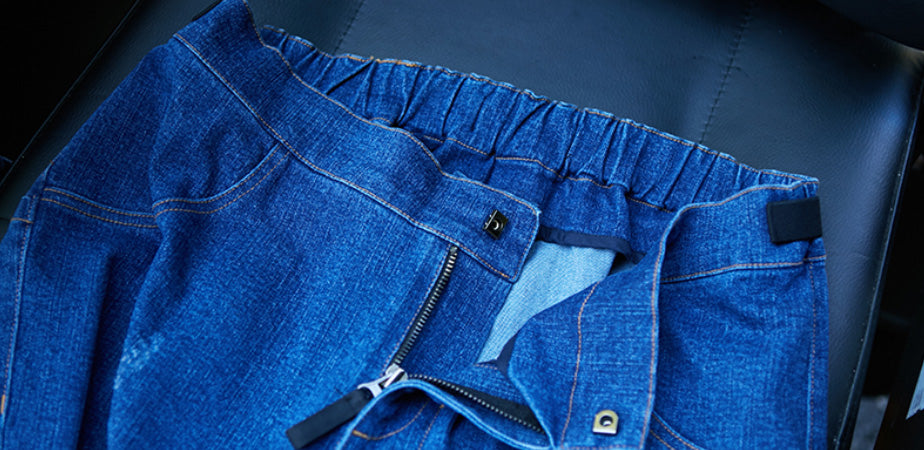 Up close view of Real Jeans inside and outside of the waist band. The metal zippers have a black fabric zipper pull, and the closure is a hook and eye. The waistband is thick and comfortable with  the inner seams reinforced and sewn cleanly for comfort and durability.