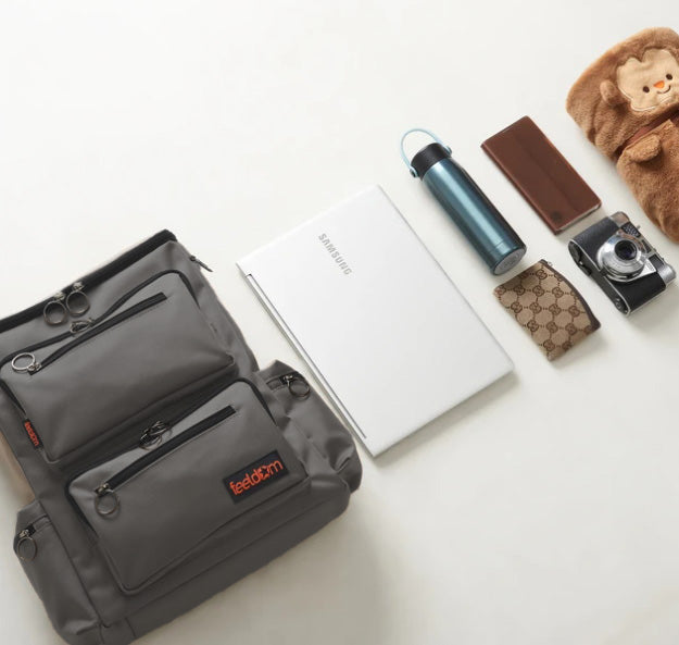 All these items are alongside the medium wheelchair bag:  A laptop, a thermos, a wallet, a camera, a cellphone and a small blanket.
