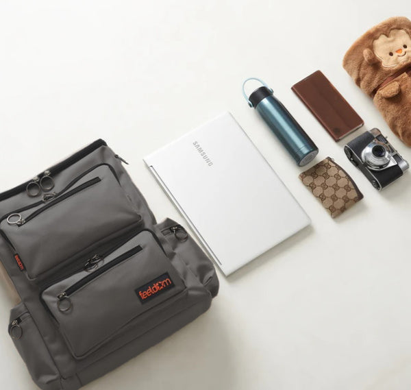All these items are alongside the medium wheelchair bag:  A laptop, a thermos, a wallet, a camera, a cellphone and a small blanket.