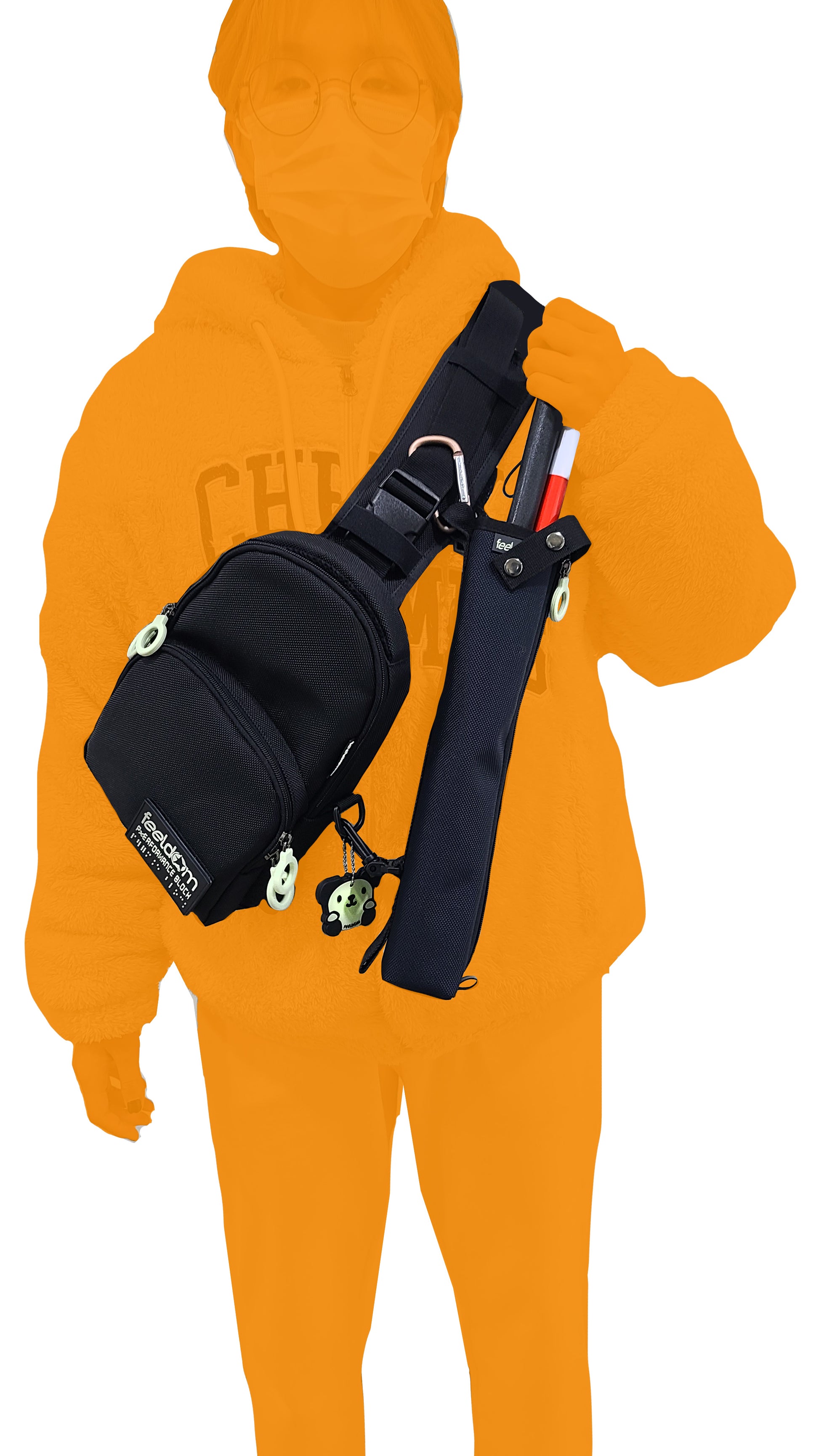 A person wearing across their front, the JAYU black adaptive crossbody bag low-vision edition. The cane pouch is attached to the shoulder strap and also clipped to the bottom side of the bag so that it remains stable. The person is taking the cane out of the cane pouch.