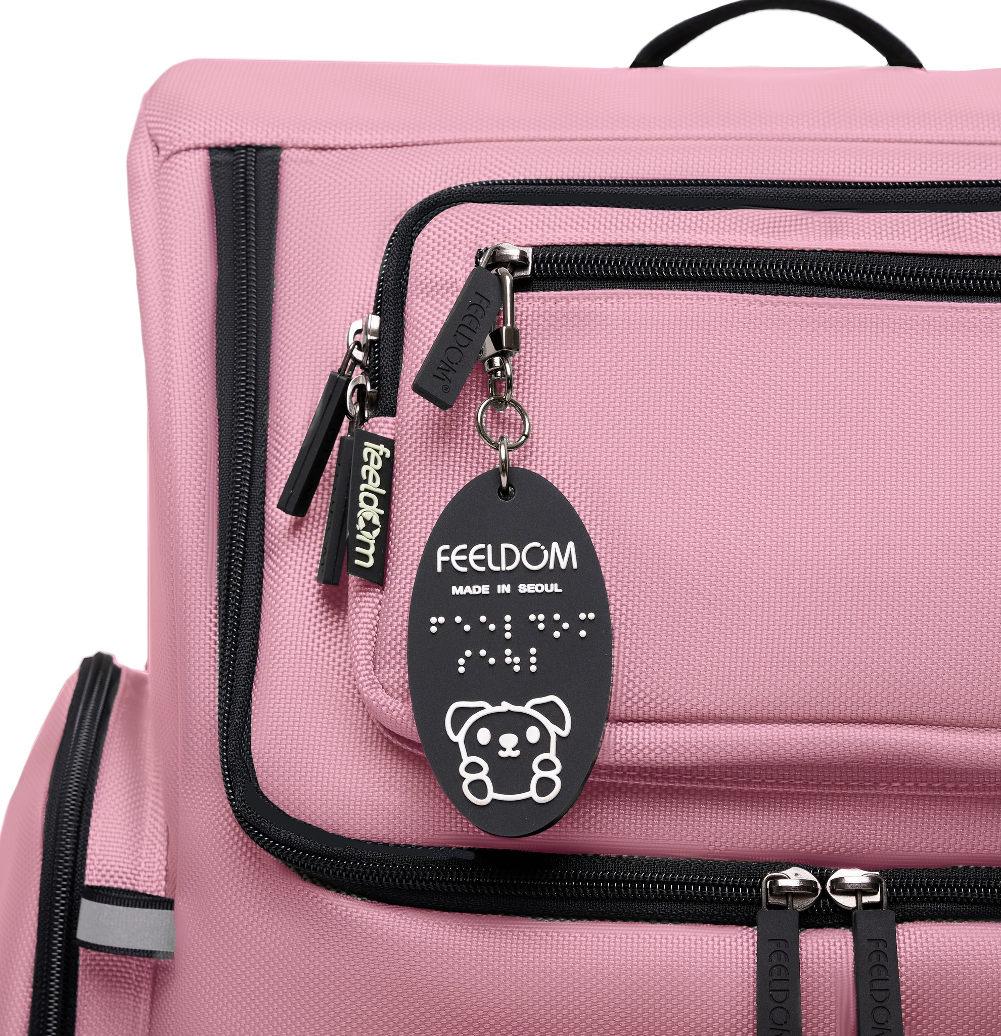Star deluxe backpack in Rose Pink with black zippers and trim. Streamlined and contour design with Feeldom label and Goldie Braille Keychain.