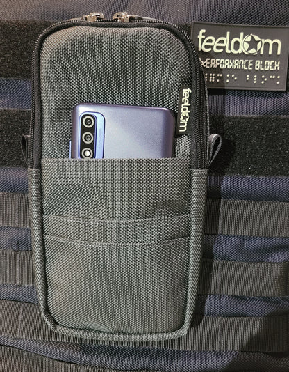 Quickie Pouch is attached to the front of Feeldom's Performance Block backpack. There is a phone in the front pocket. The phone is 1/4 visible when in the front pouch.