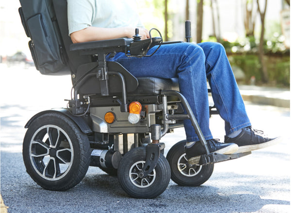 A person in an electric wheelchair is wearing Feeldom Real Jeans. They are especially contoured with a comfort seat and flexible cotton spandex high quality blue denim.
