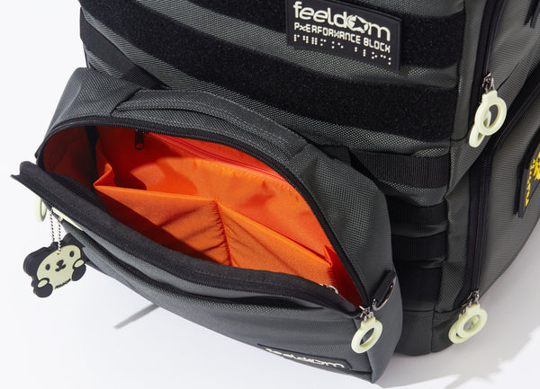 Showing the TEKNO Pouch HD on the front of the Performance Block , Large or Medium.  It has a bright orange lining inside, and pockets for your phone and other items. There are white zipper rings and glow in the dark tags on it.