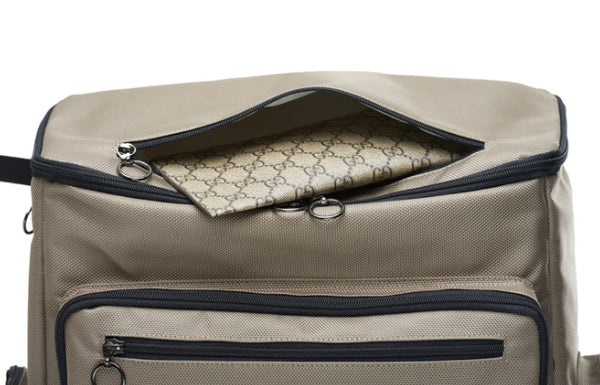 Close up detail of a Large wheelchair bag. The top lid has an accessory pouch perfect for your wallet. Image shows the bag in Beige with black trim, with a gucci wallet in the pouch.