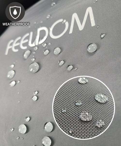 Close up of charcoal gray FEELDOM raincover. Water beads off the surface. FEELDOM logo is reflective. Weatherproof.